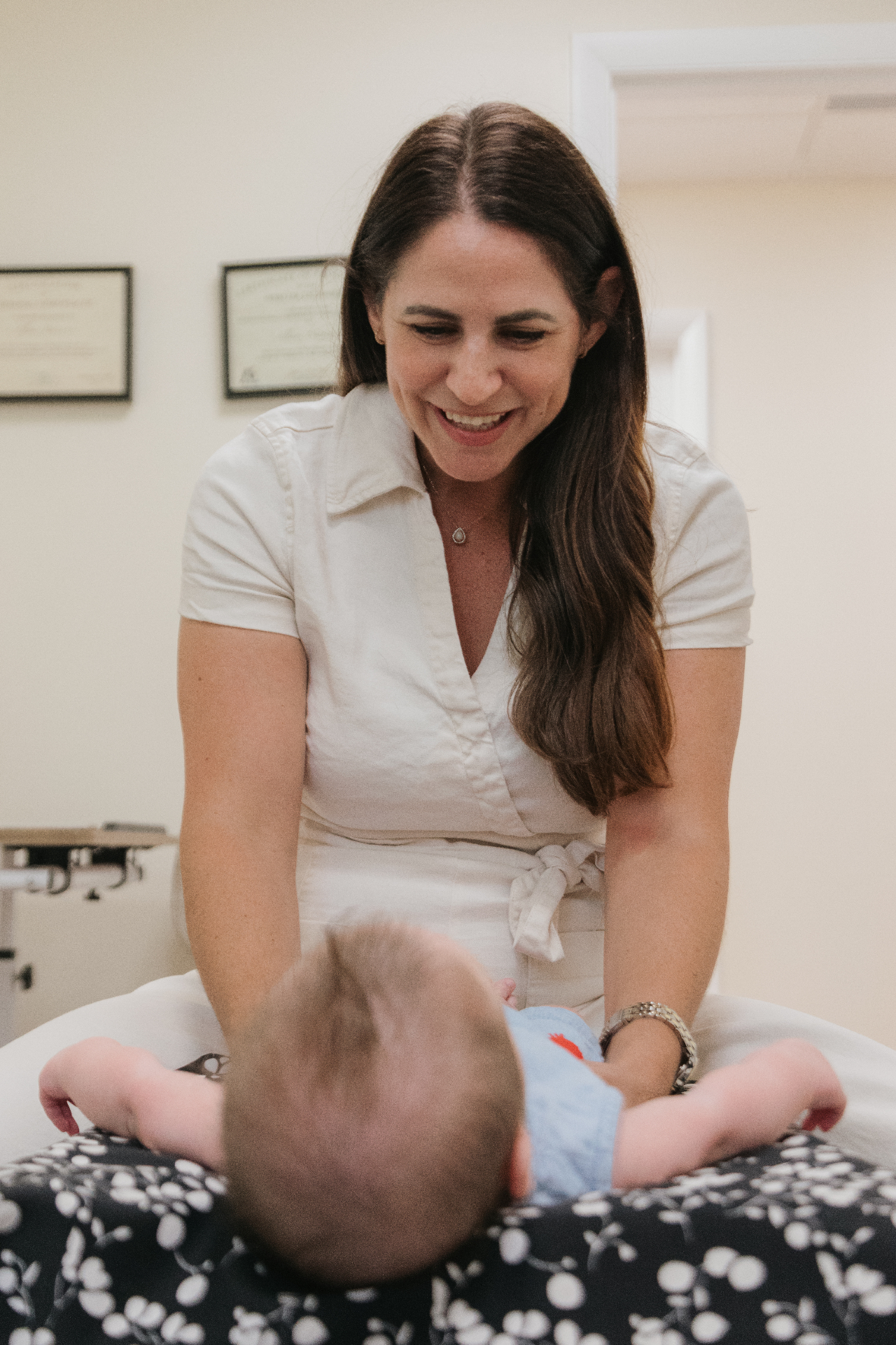 Dr. Alli adjusting an infant on a chiropractic table